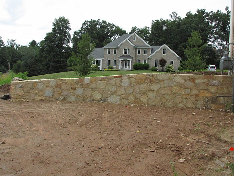Stone wall installation with layered masonry detailing and landscape integration